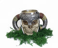Skull-shaped mug beeswax candle with ram's horns and decorative metal band on a white background