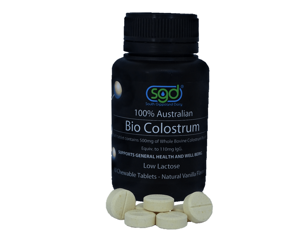 Bottle of SGD Bio Colostrum with tablets on a green background